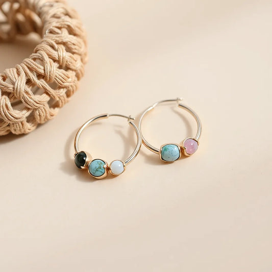 Colored howlite hoop earrings with blue, green, and pink stones arranged against a neutral background