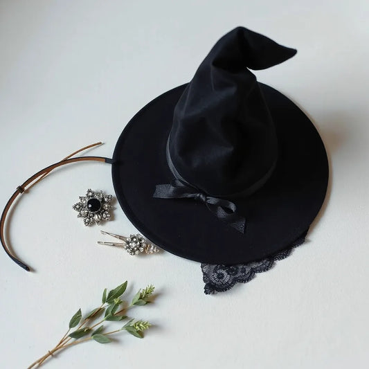 Black witch hat styled with jeweled hair clips, a lace headband, and a star hair pin