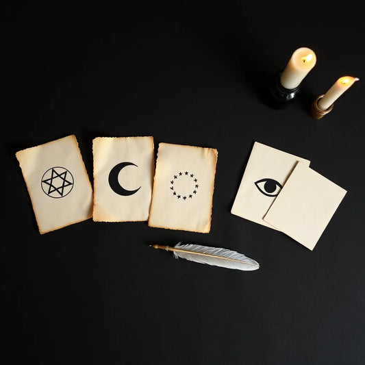 Minimal witchcraft symbols on parchment with a quill, ink bottle, and neatly arranged spell cards
