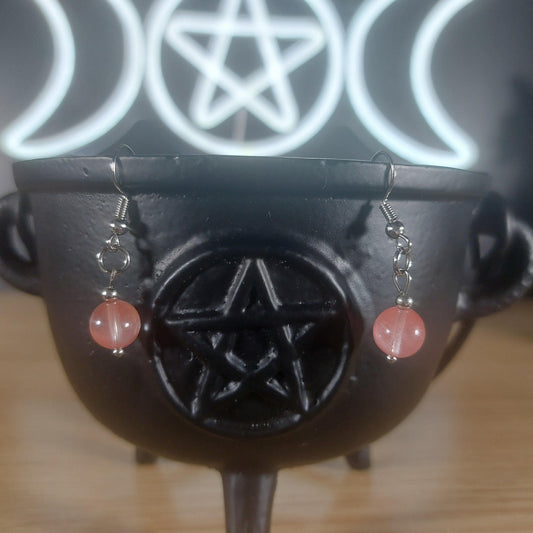 Pink rose quartz crystal beaded dangle earrings on a black cauldron with a Triple Moon pentacle symbol.