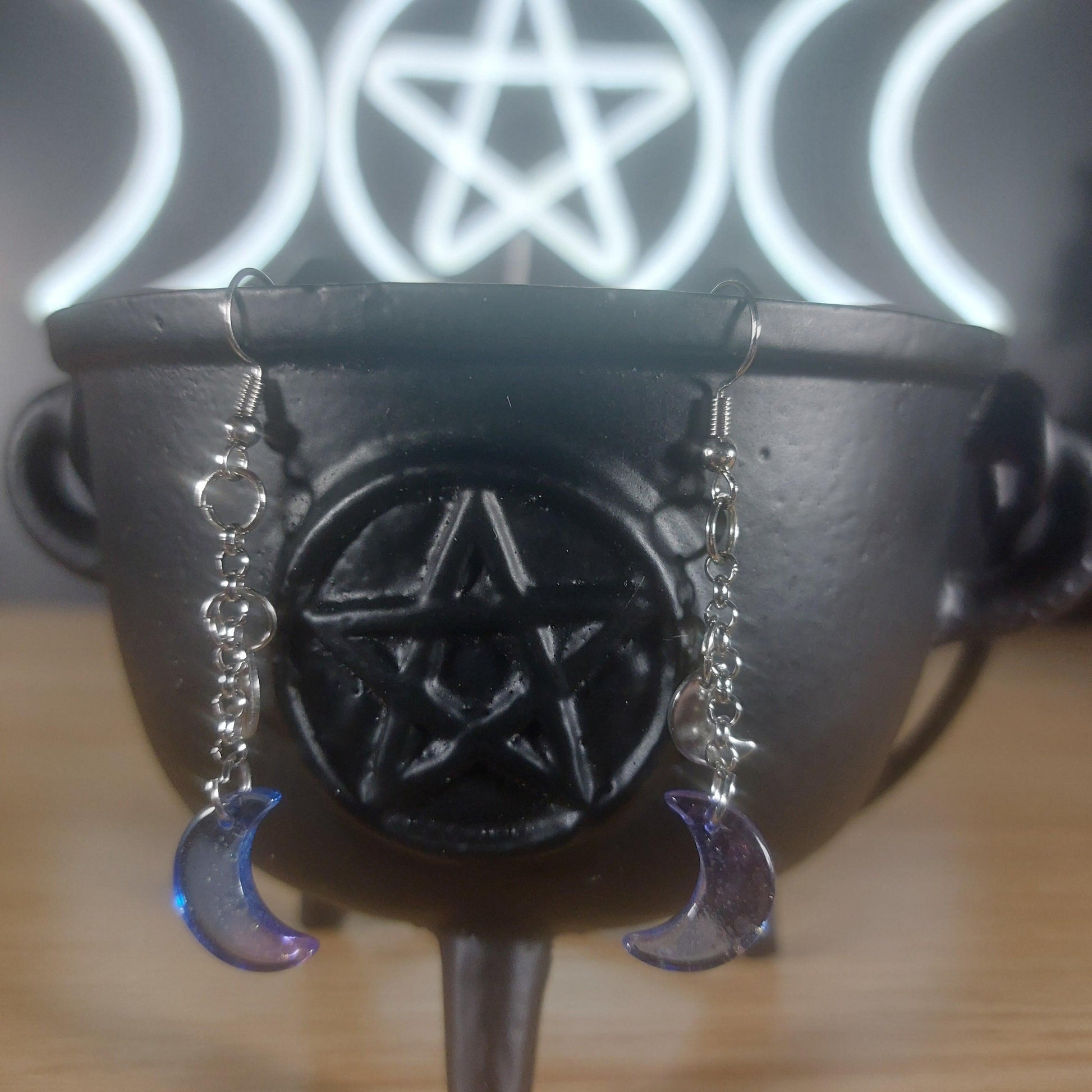 Blue/purple glass moon dangle earrings with gold specks, hanging from silver chains.