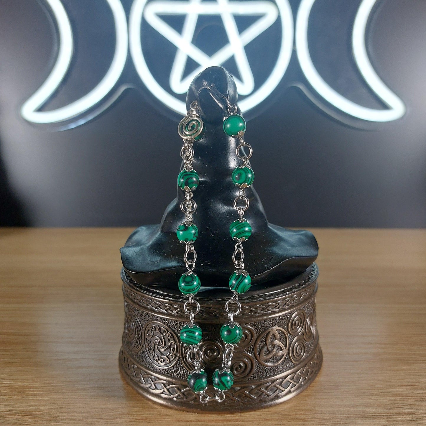 Malachite crystal beaded bracelet with stainless steel findings, bead caps, and a swirl charm.